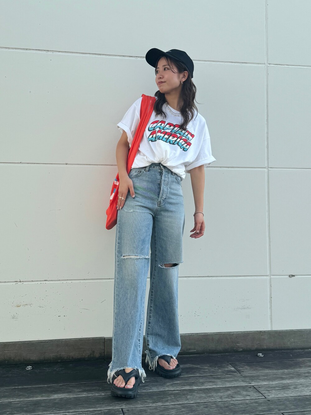 ブルー系のデニムパンツ、ホワイト系のTシャツ/カットソー、オレンジ系のエコバッグ/サブバッグを着用したレディースの夏コーディネートの4枚目の写真