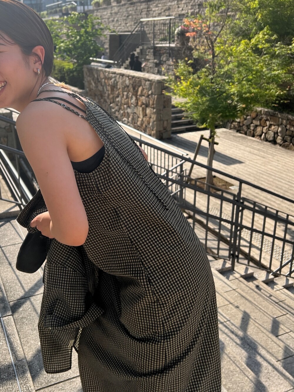 ベージュ系のワンピース、ベージュ系のシャツ/ブラウス、ブラック系のサンダルを着用したレディースの春コーディネートの8枚目の写真