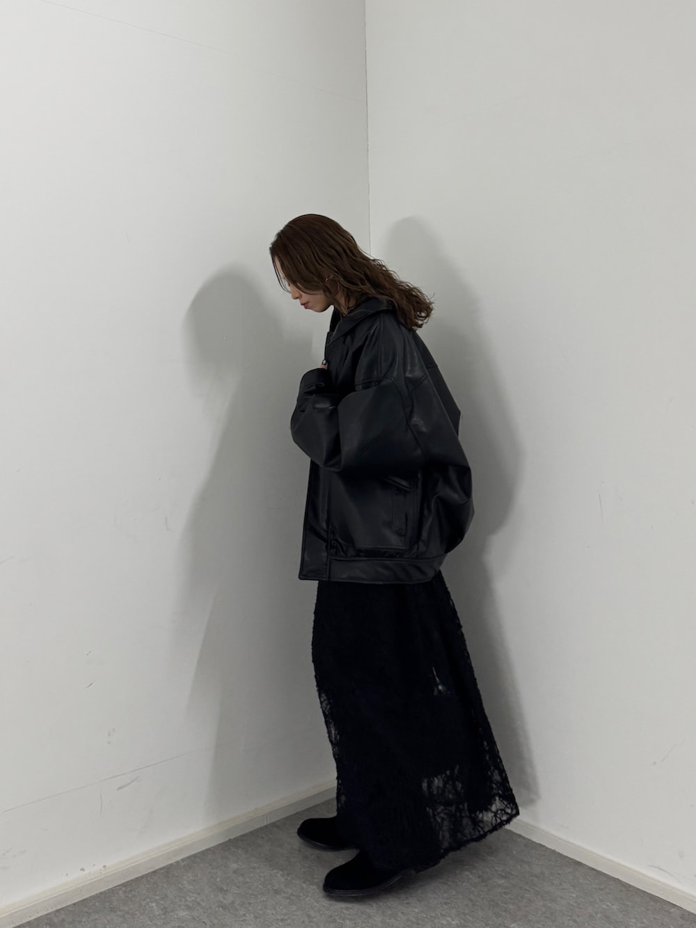 ブラック系のワンピース、ブラック系のブルゾン、ブラック系のブーツを着用したレディースの冬コーディネートの3枚目の写真