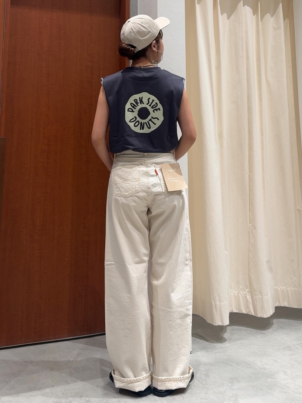 ホワイト系のデニムパンツ、グレー系のタンクトップ、ブラック系のサンダルを着用したレディースの春コーディネートの4枚目の写真