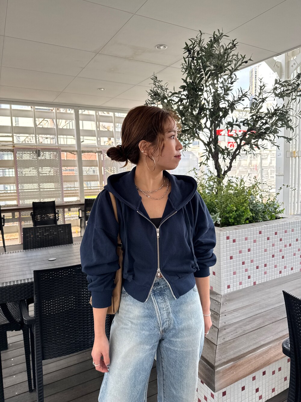 ブルー系のパーカー、ブルー系のデニムパンツ、シルバー系のネックレスを着用したレディースの冬コーディネートの7枚目の写真