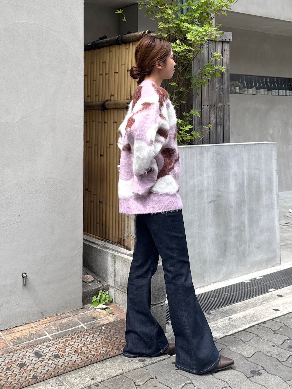 ブルー系のデニムパンツ、ブラウン系のブーツ、ピンク系のニット/セーターを着用したレディースの秋コーディネートの2枚目の写真
