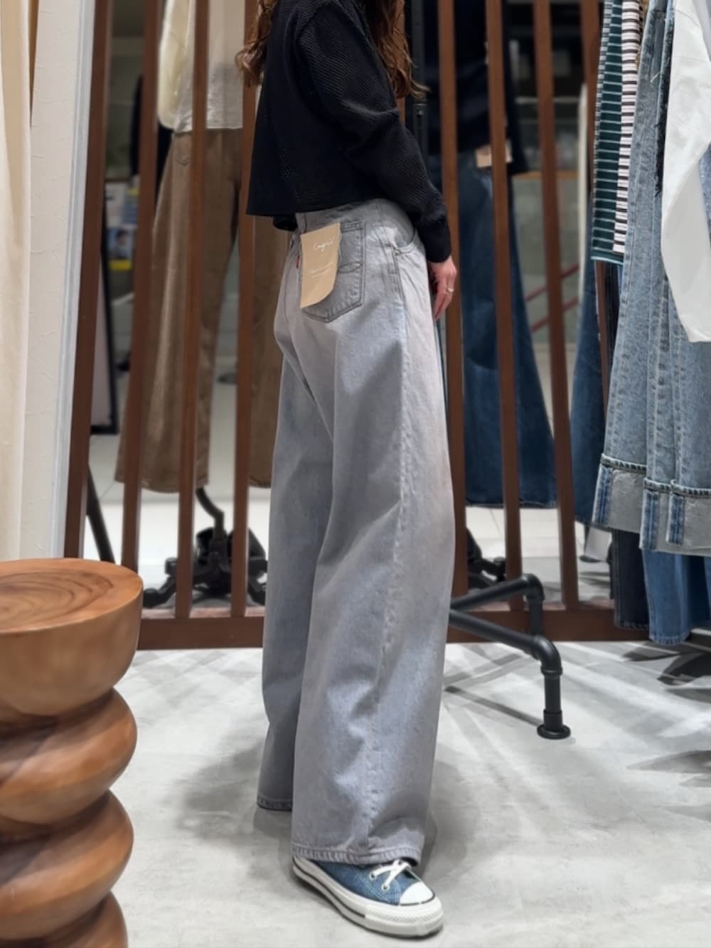 ブルー系のデニムパンツ、ブラック系のカーディガン/ボレロ、パープル系のTシャツ/カットソーを着用したレディースの春コーディネートの5枚目の写真