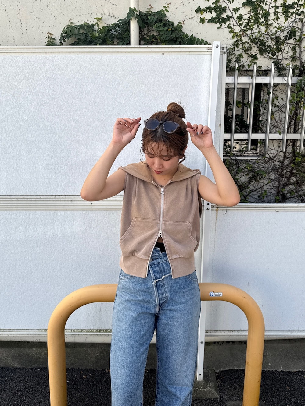 ベージュ系のパーカー、ブルー系のデニムパンツを着用したレディースの夏コーディネートの7枚目の写真