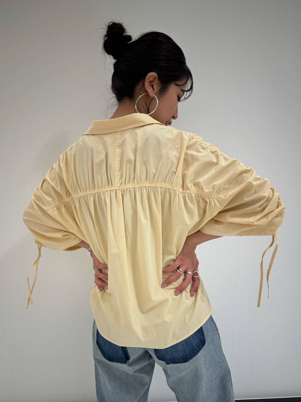 イエロー系のシャツ/ブラウス、ブルー系のデニムパンツ、グレー系のTシャツ/カットソーを着用したレディースの春コーディネートの4枚目の写真