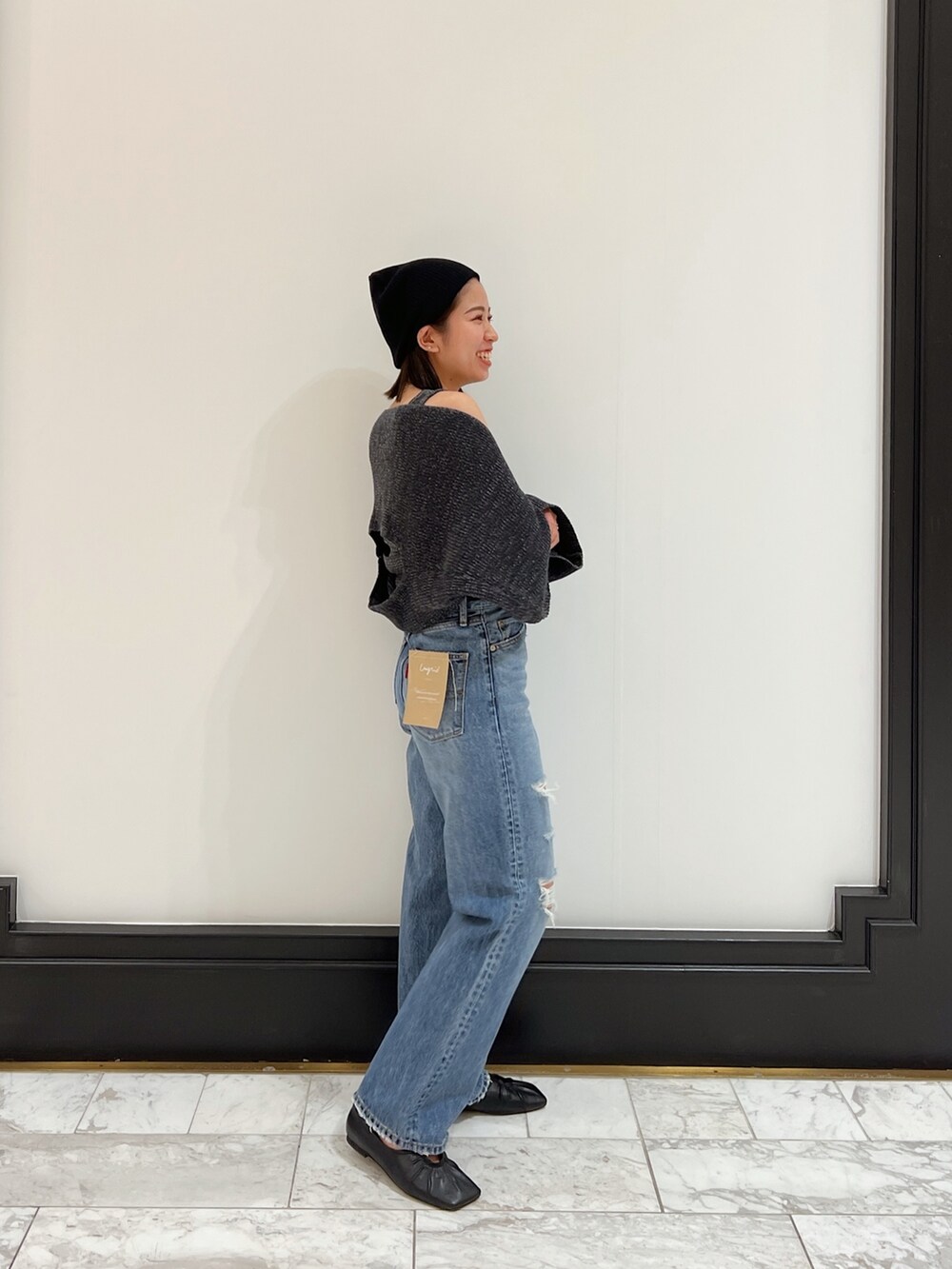 ブルー系のデニムパンツ、グレー系のニット/セーター、ブラック系のパンプスを着用したレディースの春コーディネートの7枚目の写真