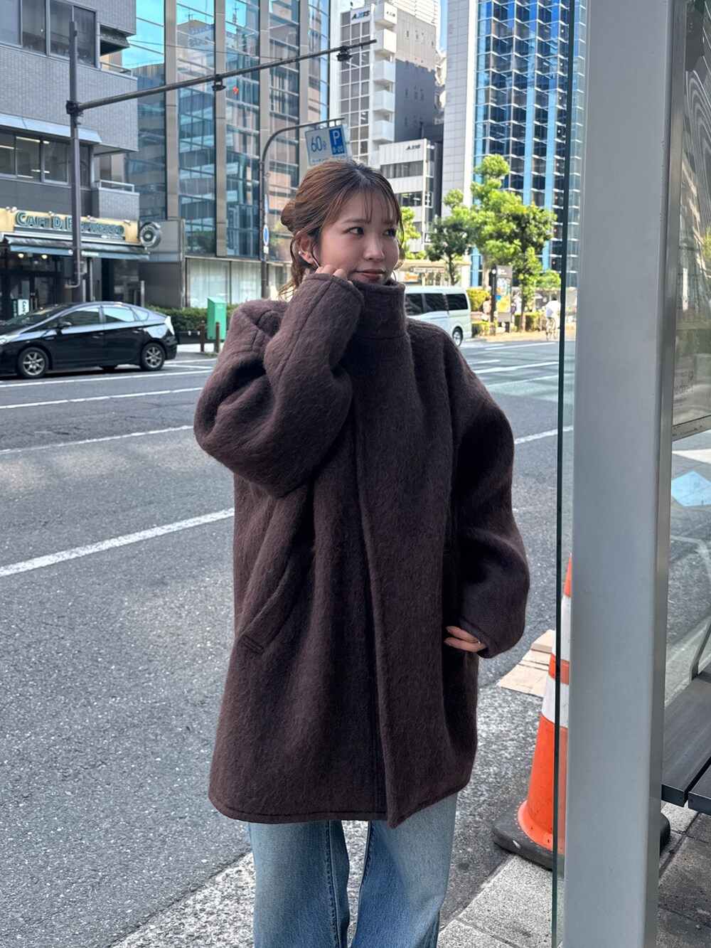 ブラウン系のダウンジャケット/コート、ブルー系のデニムパンツ、ブラウン系のブーツを着用したレディースの秋コーディネートの9枚目の写真