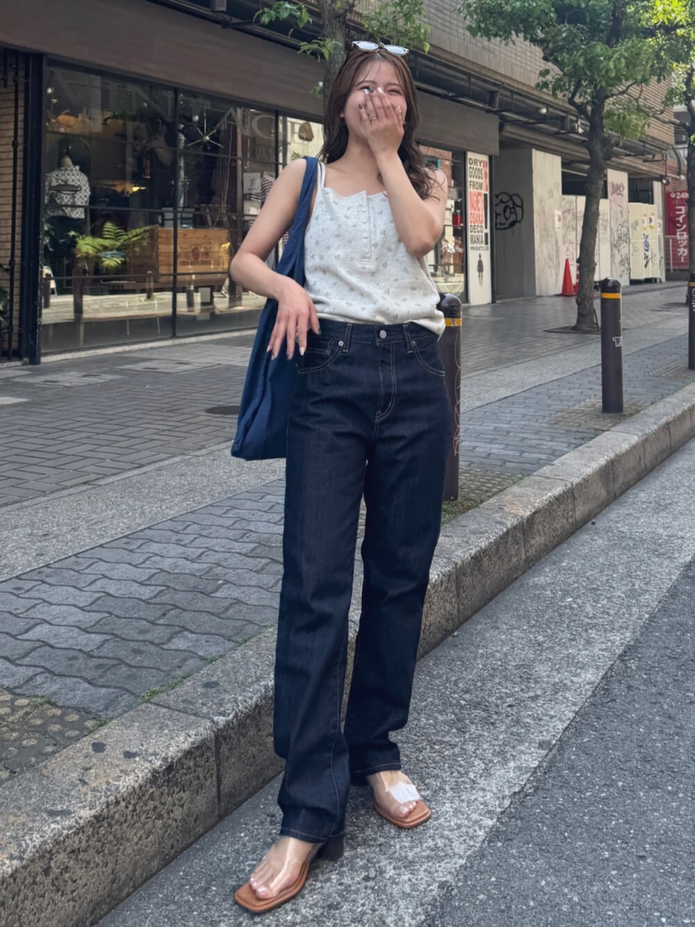 ブルー系のデニムパンツ、その他のサンダル、ブルー系のトートバッグを着用したレディースの春コーディネートの7枚目の写真