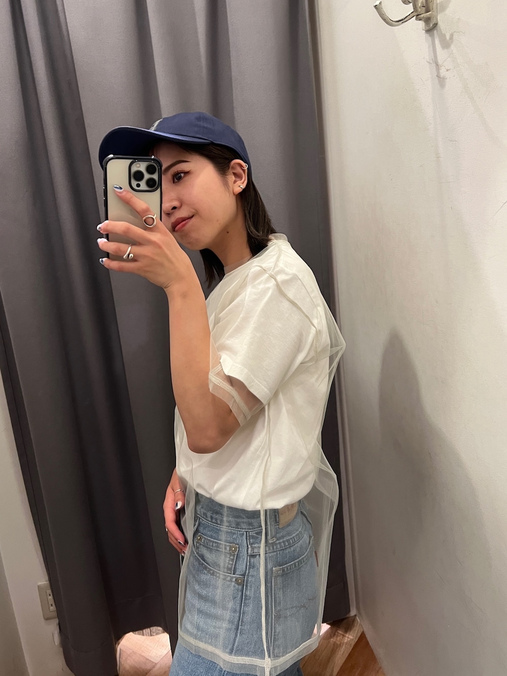 ブルー系のデニムパンツ、ブラック系のサンダル、ホワイト系のTシャツ/カットソーを着用したレディースの春コーディネートの4枚目の写真
