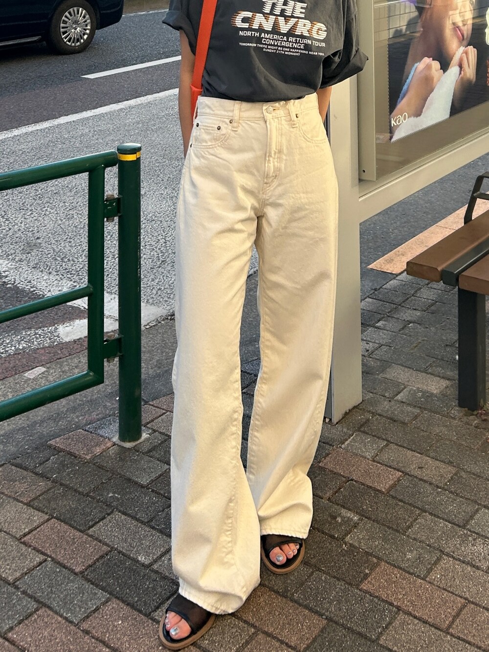 グレー系のTシャツ/カットソー、ホワイト系のデニムパンツ、オレンジ系のショルダーバッグを着用したレディースの春コーディネートの7枚目の写真