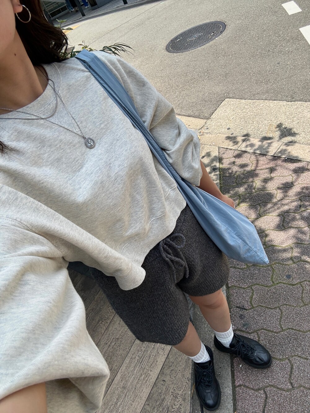 グレー系のその他パンツ、グレー系のスウェット、ブルー系のエコバッグ/サブバッグを着用したレディースの夏コーディネートの8枚目の写真