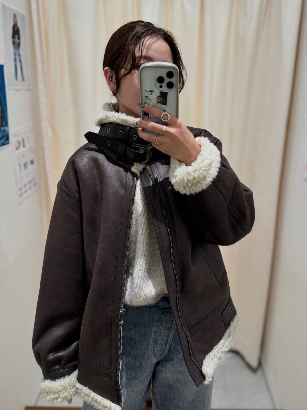 ブルー系のデニムパンツ、ブラウン系のブルゾン、ホワイト系のニット/セーターを着用したレディースの秋コーディネートの3枚目の写真