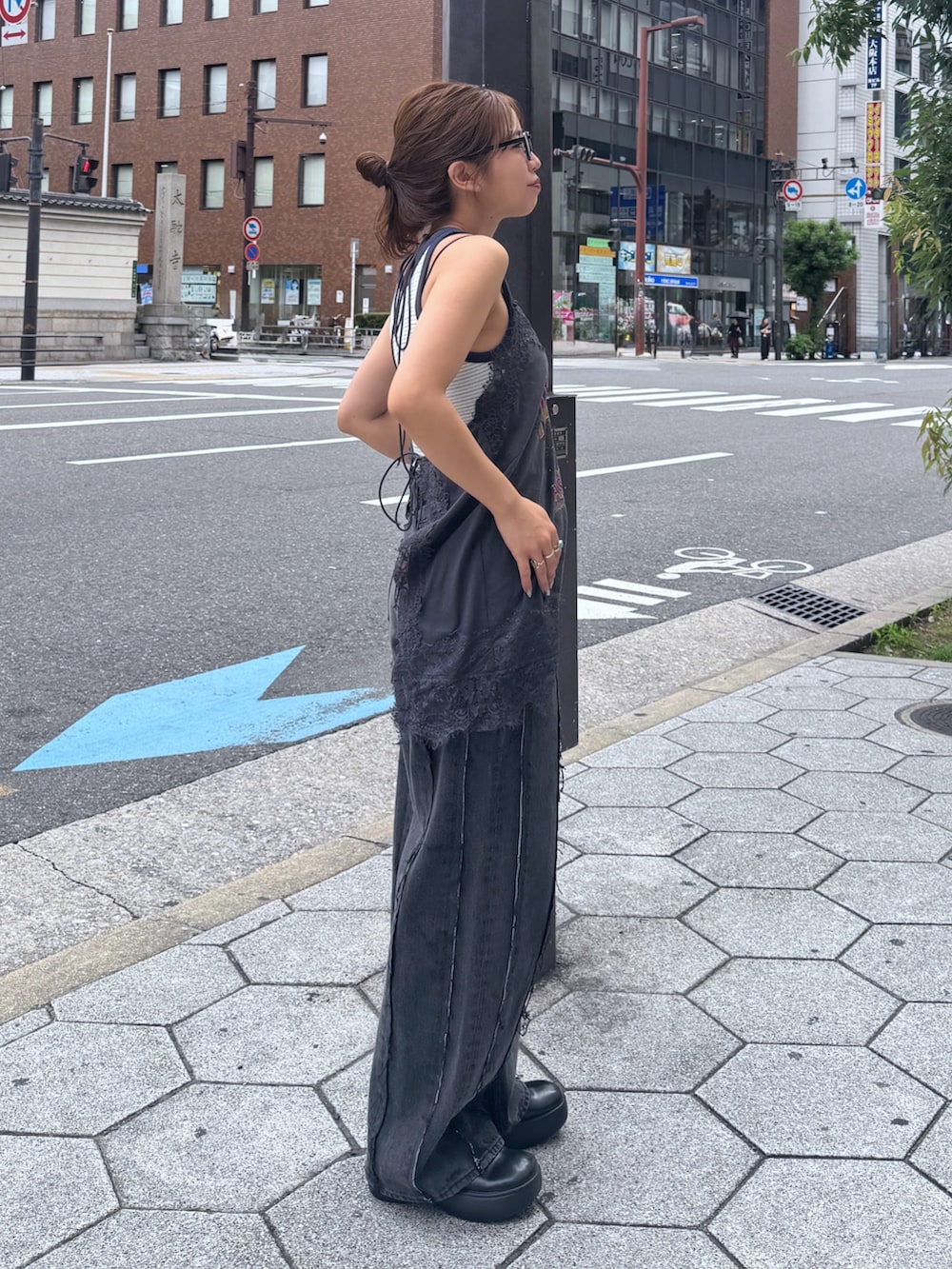 グレー系のキャミソール、ホワイト系のタンクトップ、ブラック系のデニムパンツを着用したレディースの夏コーディネートの7枚目の写真