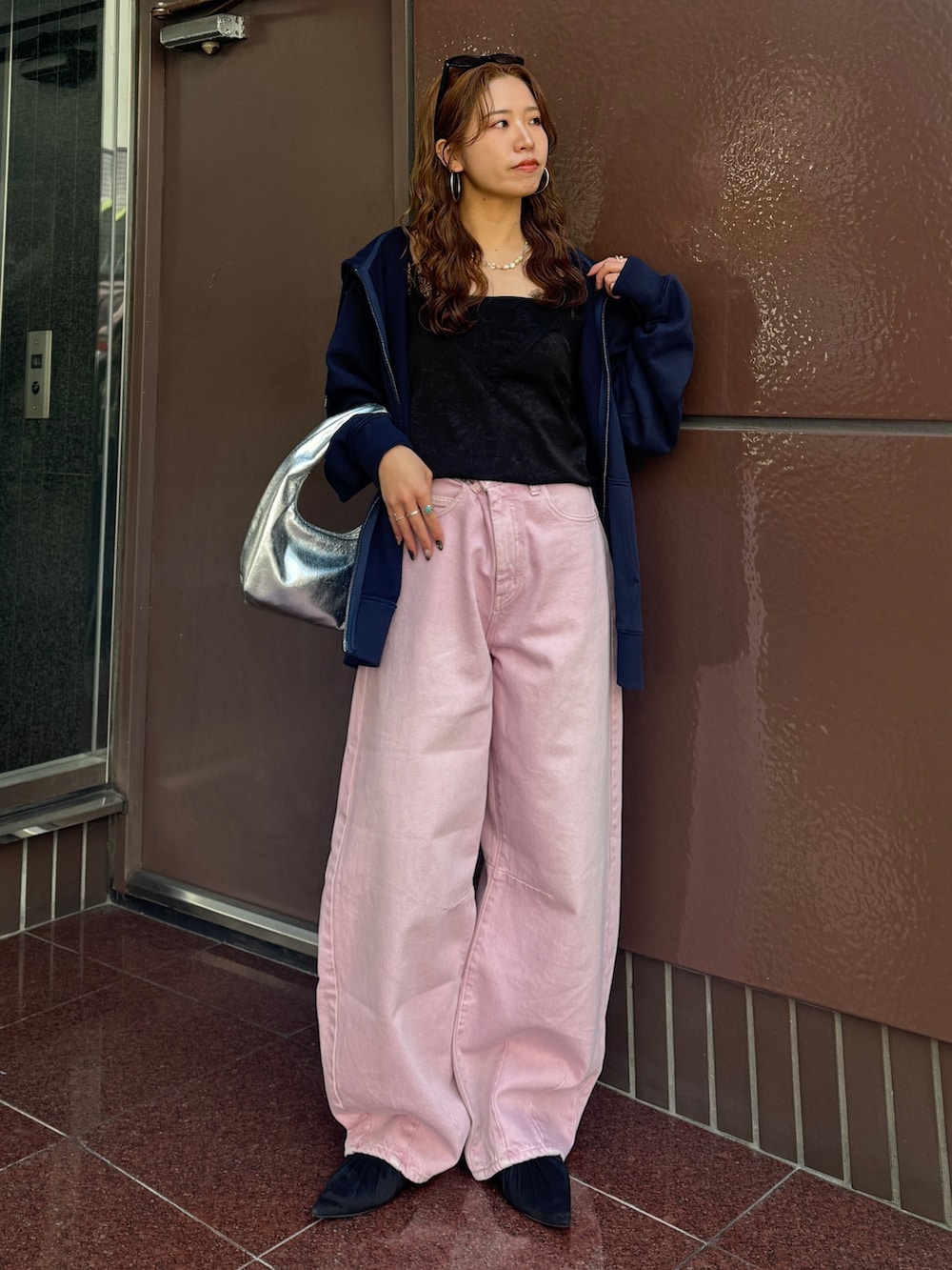 ブルー系のパーカー、ピンク系のデニムパンツ、ブラック系のキャミソールを着用したレディースの春コーディネートの2枚目の写真