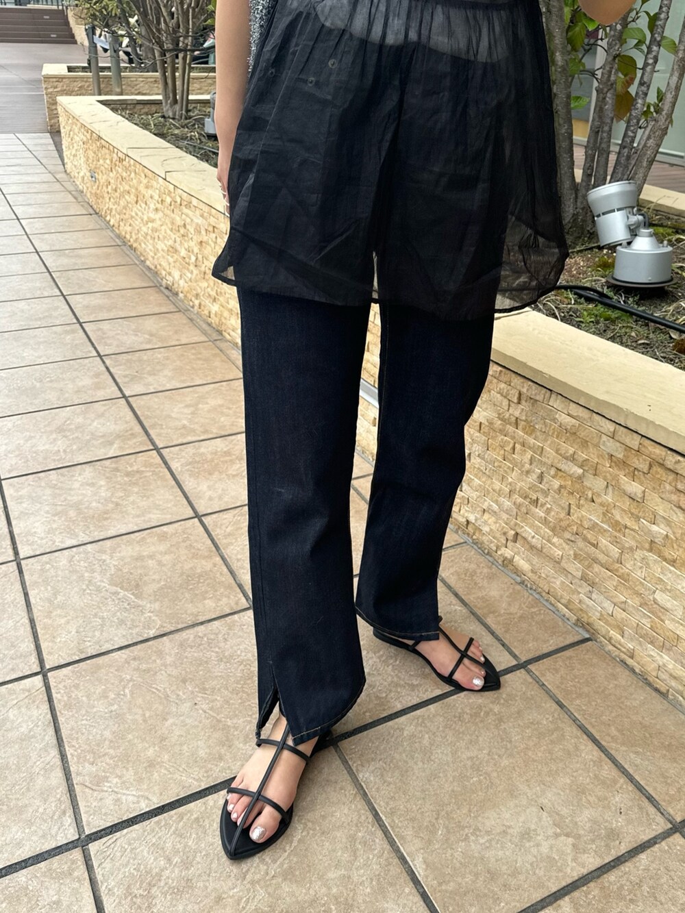 ブルー系のデニムパンツ、ホワイト系のTシャツ/カットソー、ブラック系のキャミソールを着用したレディースの春コーディネートの7枚目の写真