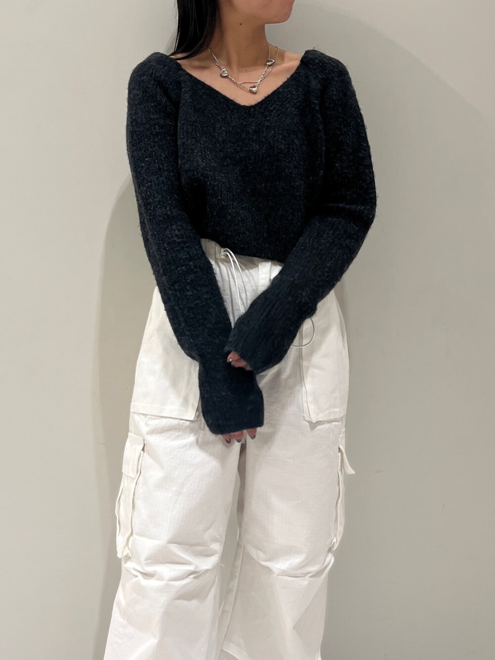 ブラック系のブーツ、ホワイト系のカーゴパンツ、グレー系のニット/セーターを着用したレディースの秋コーディネートの2枚目の写真