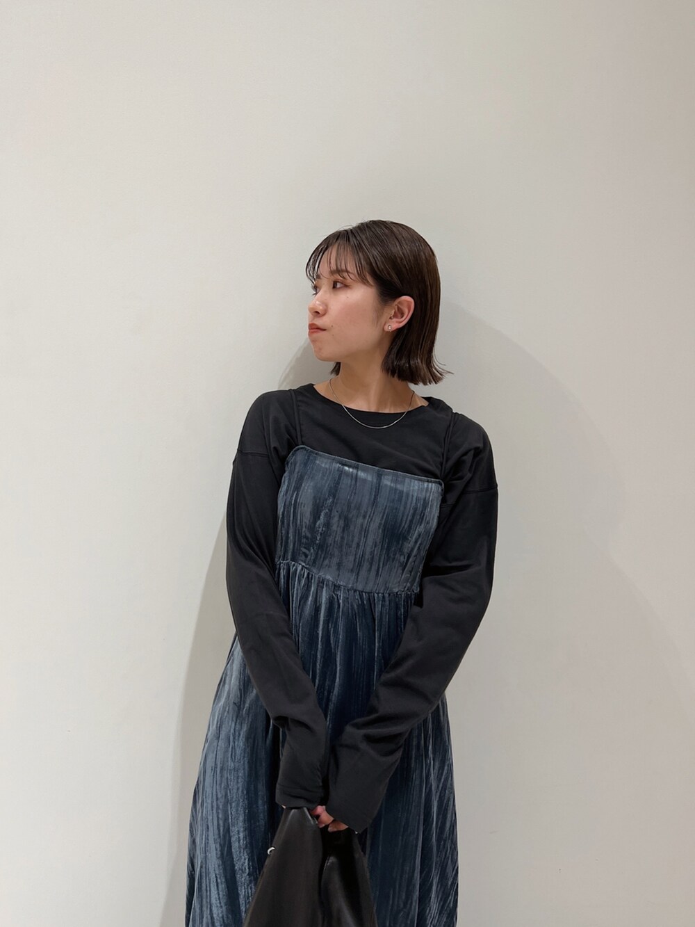 ブルー系のワンピース、ブラック系のTシャツ/カットソー、ブラック系のブーツを着用したレディースの冬コーディネートの7枚目の写真