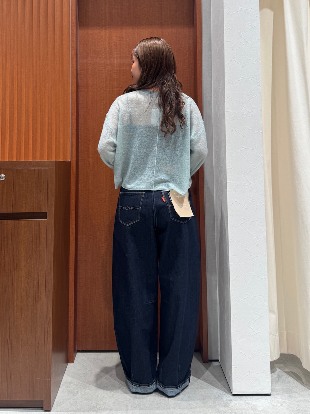 グリーン系のニット/セーター、ブルー系のデニムパンツ、ブラック系のその他シューズを着用したレディースの秋コーディネートの4枚目の写真