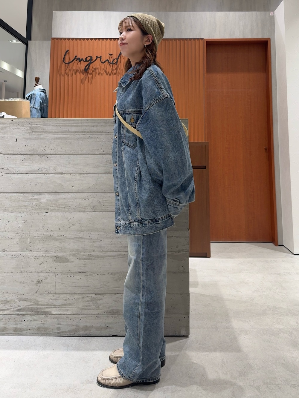 ブルー系のデニムジャケット、ブルー系のデニムパンツ、ホワイト系のタンクトップを着用したレディースの夏コーディネートの5枚目の写真