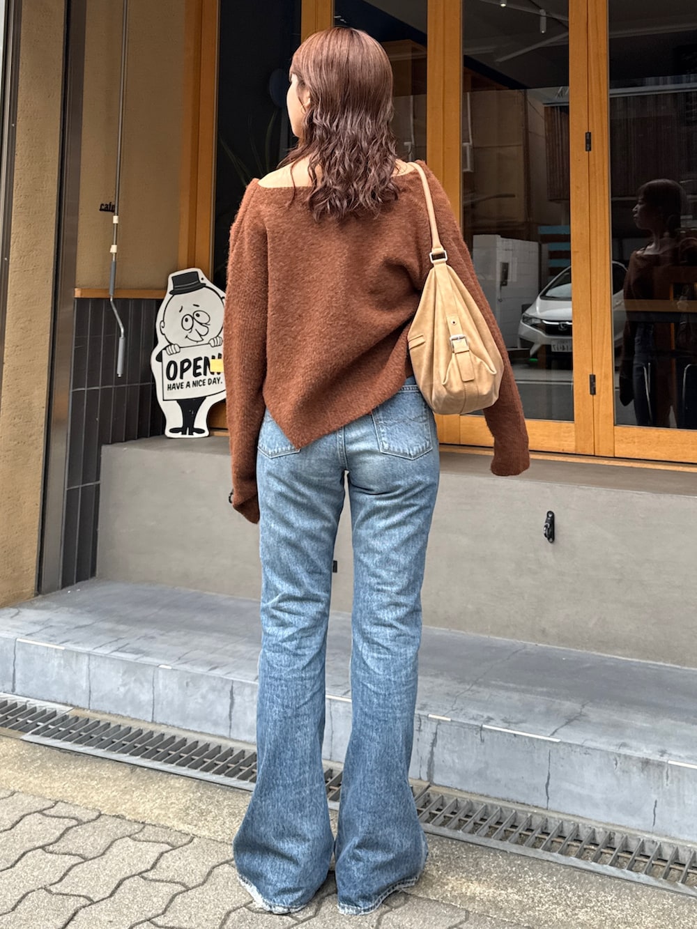 ブルー系のデニムパンツ、ブラウン系のブーツ、ブラウン系のニット/セーターを着用したレディースの秋コーディネートの8枚目の写真