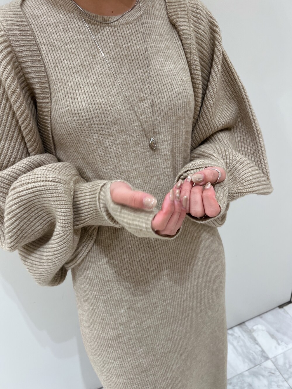 グレー系のワンピース、ブラウン系のブーツを着用したレディースの秋コーディネートの9枚目の写真