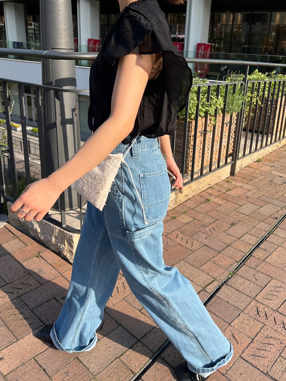 ブルー系のデニムパンツ、ブラック系のパンプス、ブラック系のシャツ/ブラウスを着用したレディースの春コーディネートの6枚目の写真