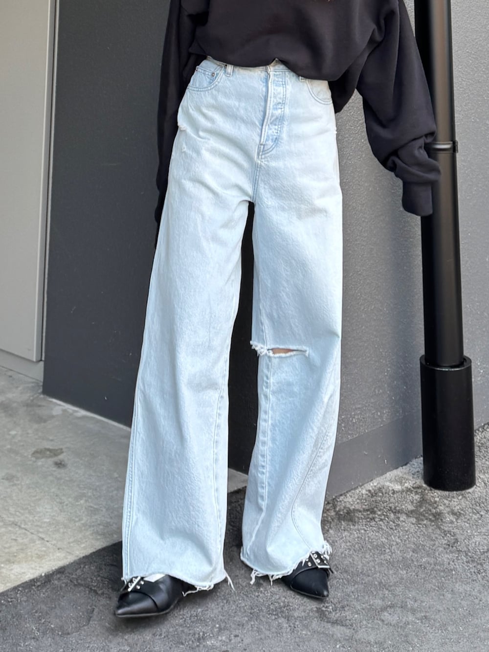 ブラック系のスウェット、グレー系のTシャツ/カットソー、ブルー系のデニムパンツを着用したレディースの春コーディネートの7枚目の写真