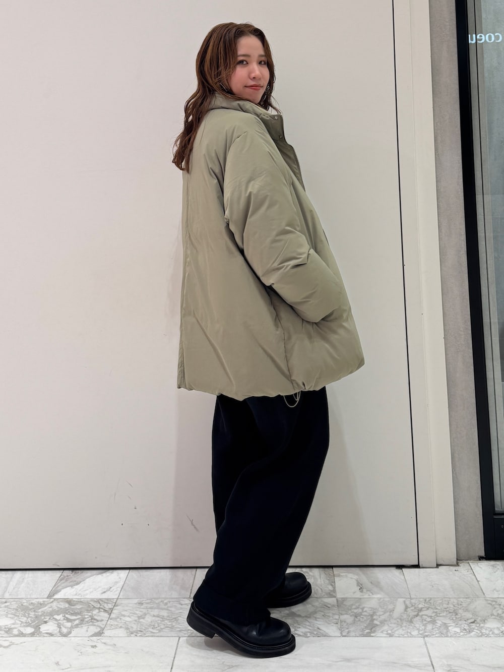 ブラック系のニット/セーター、ホワイト系のTシャツ/カットソー、ブラック系のその他パンツを着用したレディースの冬コーディネートの3枚目の写真