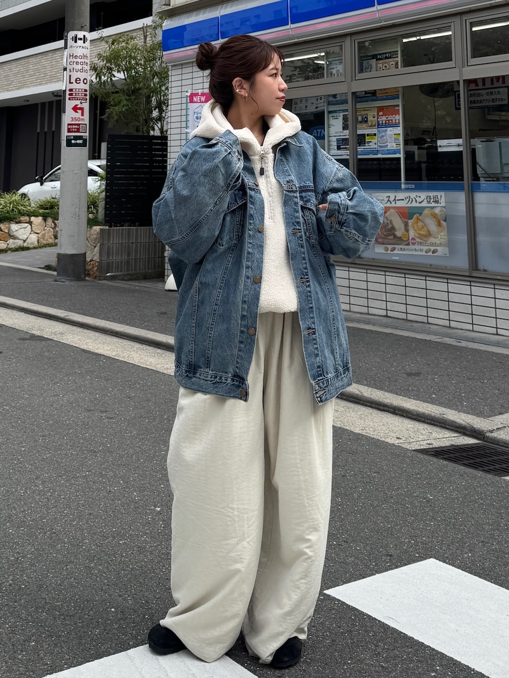 ブルー系のデニムジャケット、ホワイト系のパーカー、ホワイト系のその他パンツを着用したレディースの秋コーディネートの2枚目の写真