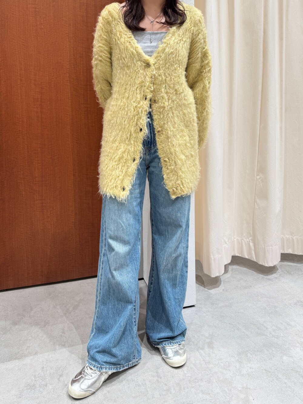 ブルー系のデニムパンツ、イエロー系のカーディガン/ボレロを着用したレディースの秋コーディネートの7枚目の写真