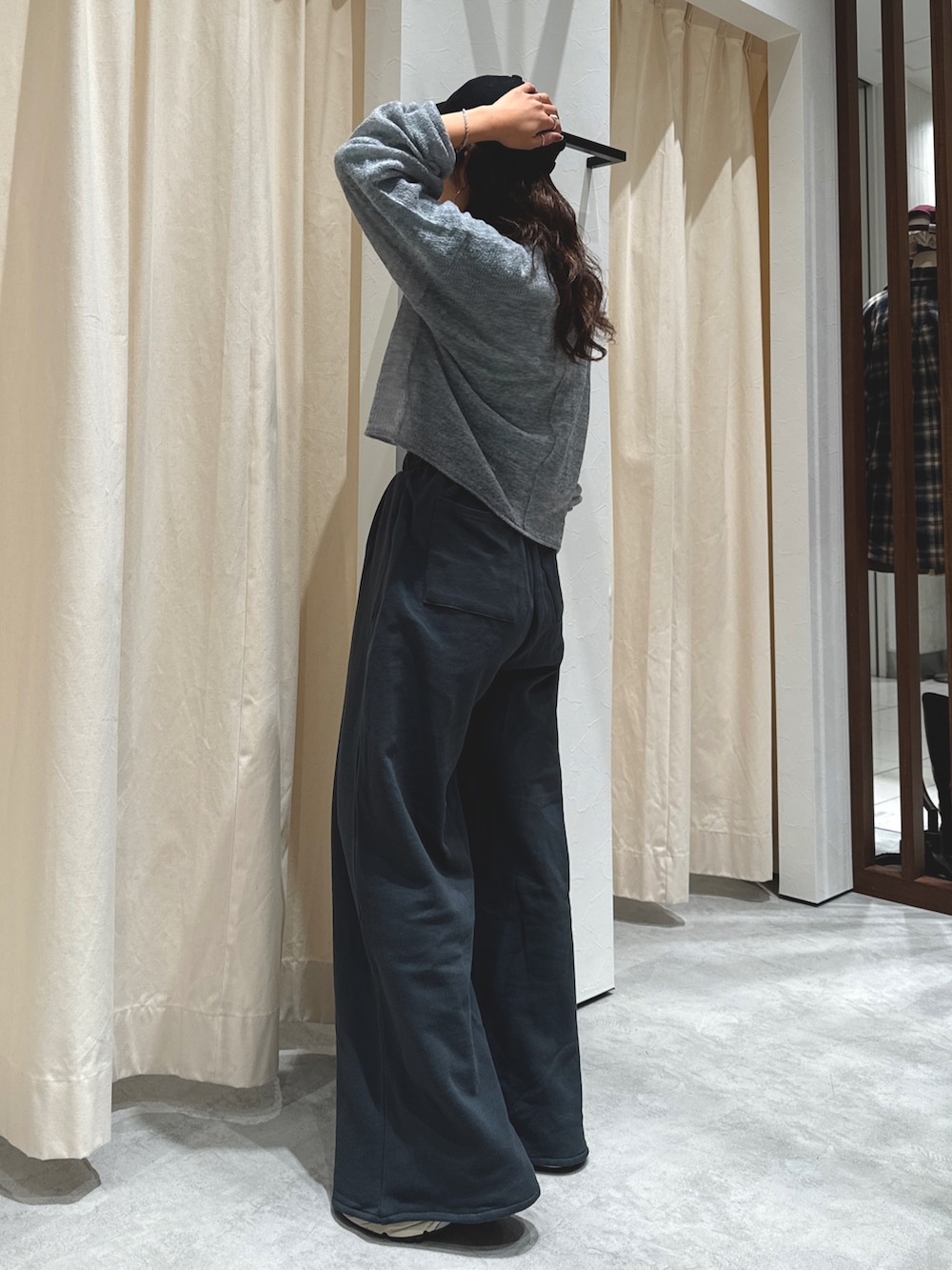 グレー系のニット/セーター、グリーン系のTシャツ/カットソー、グレー系のスウェットパンツを着用したレディースの秋コーディネートの5枚目の写真