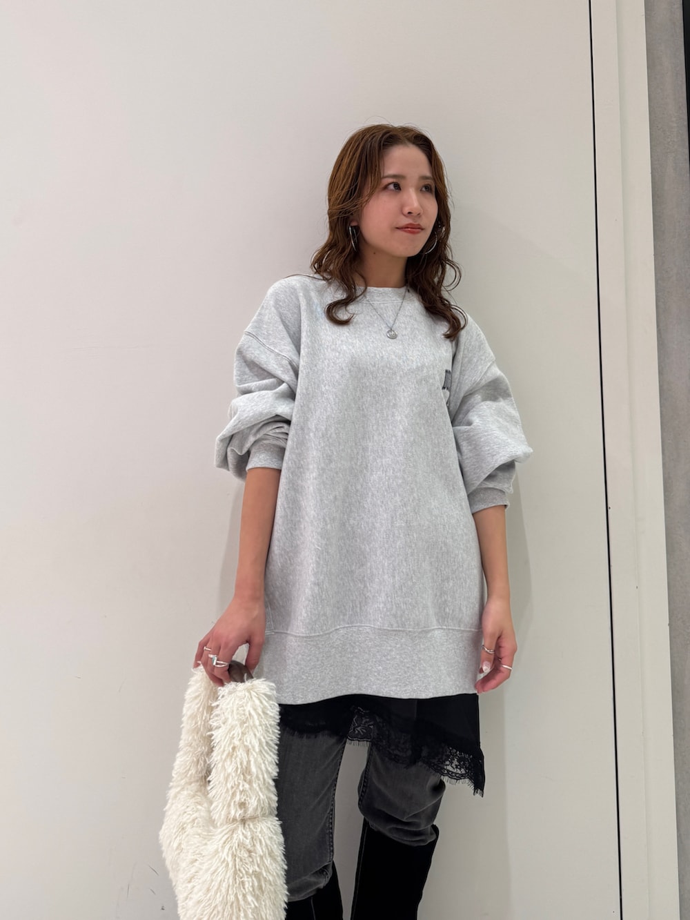 グレー系のスウェット、ブラック系のキャミソール、ブラック系のデニムパンツを着用したレディースの冬コーディネートの9枚目の写真