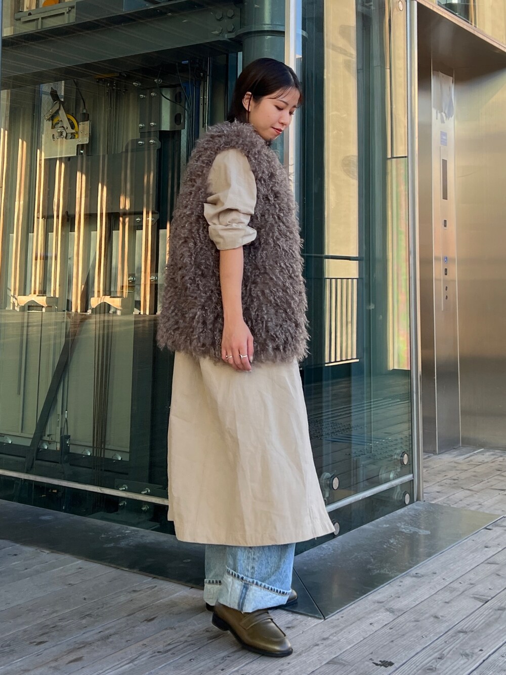 グリーン系のローファー、ブルー系のデニムパンツ、ブラック系のキャミソールを着用したレディースの秋コーディネートの3枚目の写真