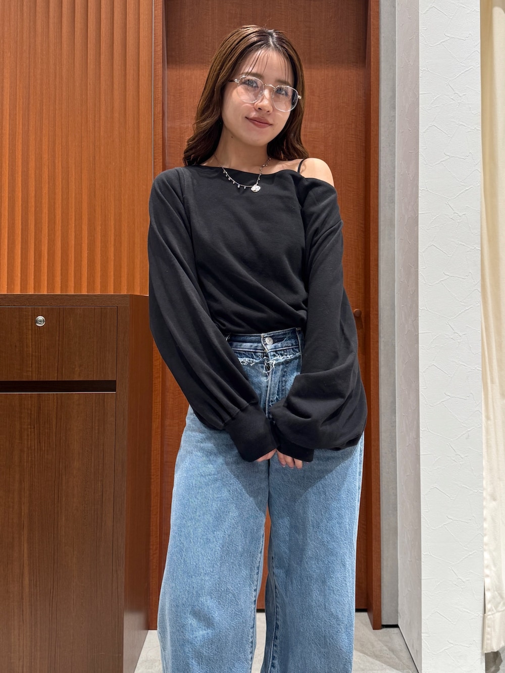 ブルー系のデニムパンツ、ブラック系のスウェット、シルバー系のメガネを着用したレディースの秋コーディネートの7枚目の写真
