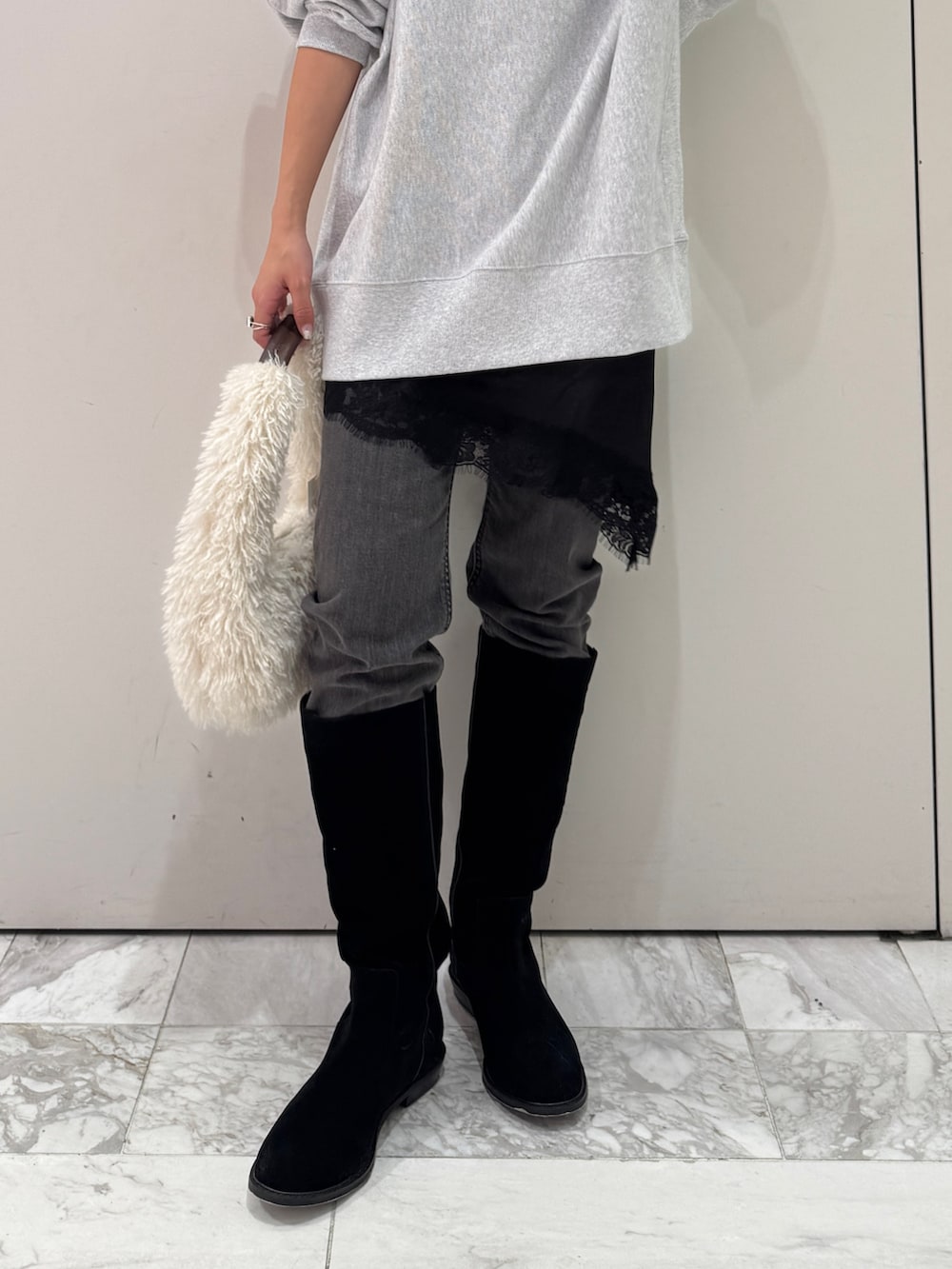 グレー系のスウェット、ブラック系のキャミソール、ブラック系のデニムパンツを着用したレディースの冬コーディネートの2枚目の写真