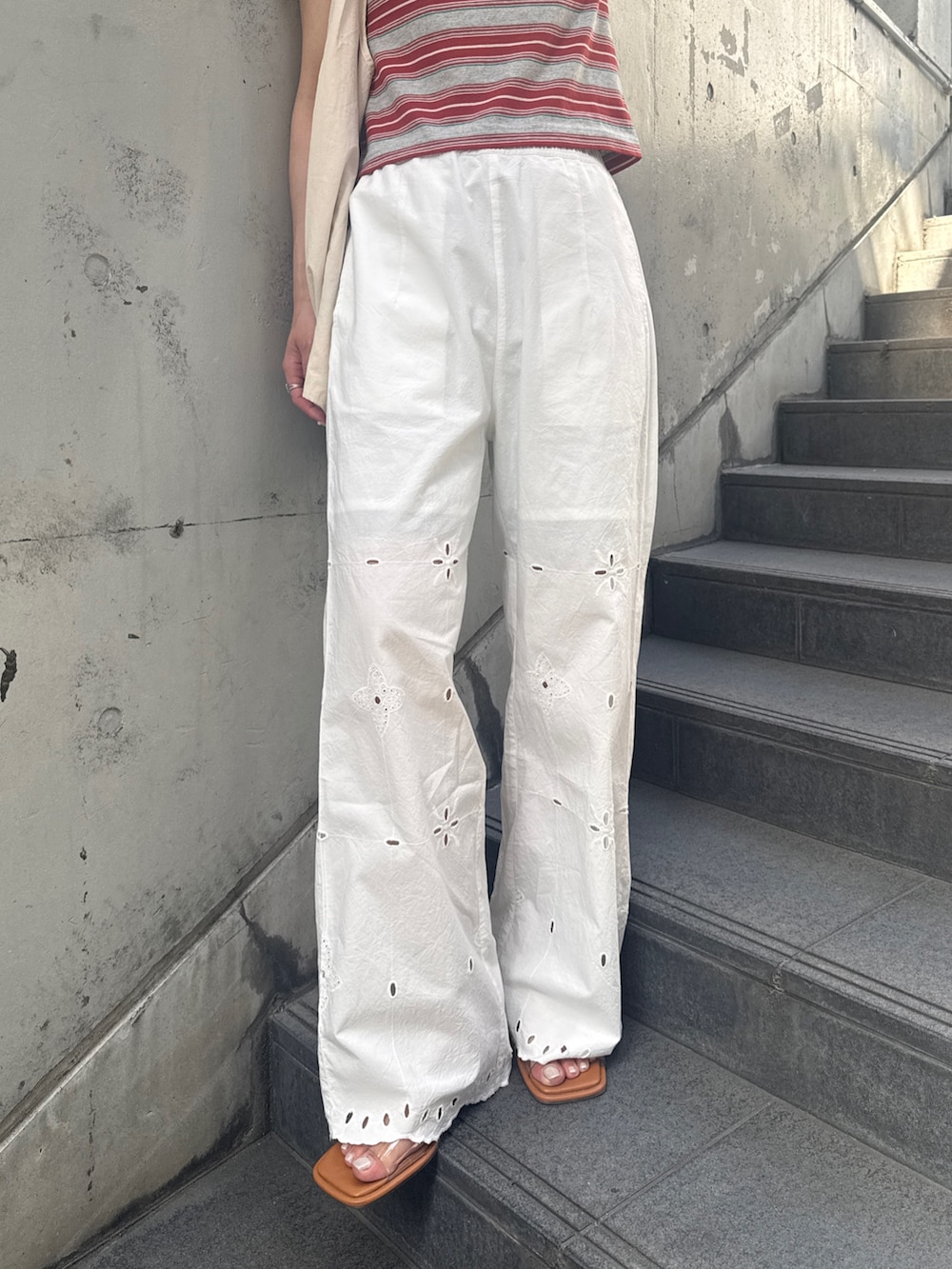 ホワイト系のその他パンツ、レッド系のTシャツ/カットソー、その他のサンダルを着用したレディースの春コーディネートの6枚目の写真