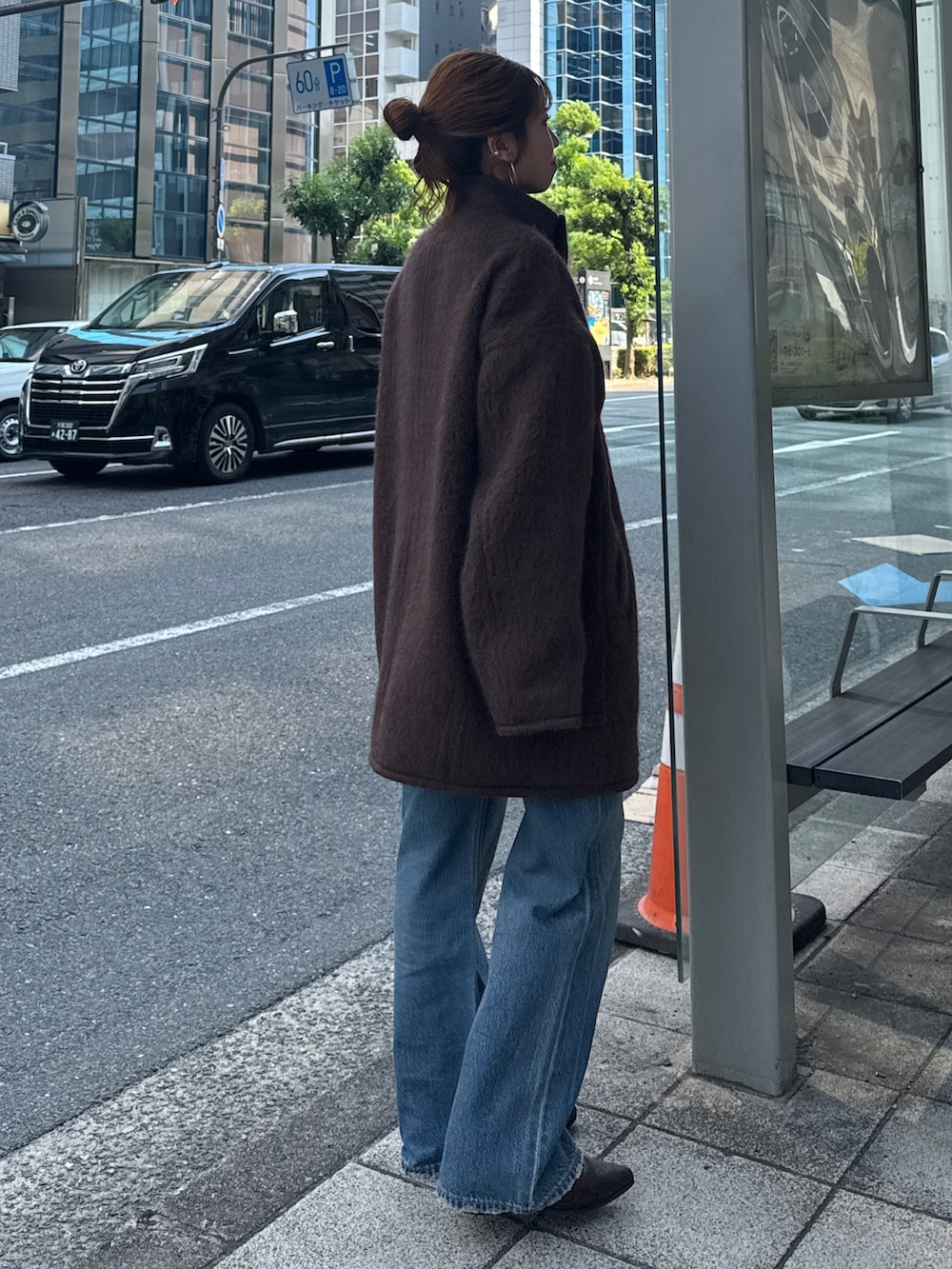 ブラウン系のダウンジャケット/コート、ブルー系のデニムパンツ、ブラウン系のブーツを着用したレディースの秋コーディネートの5枚目の写真