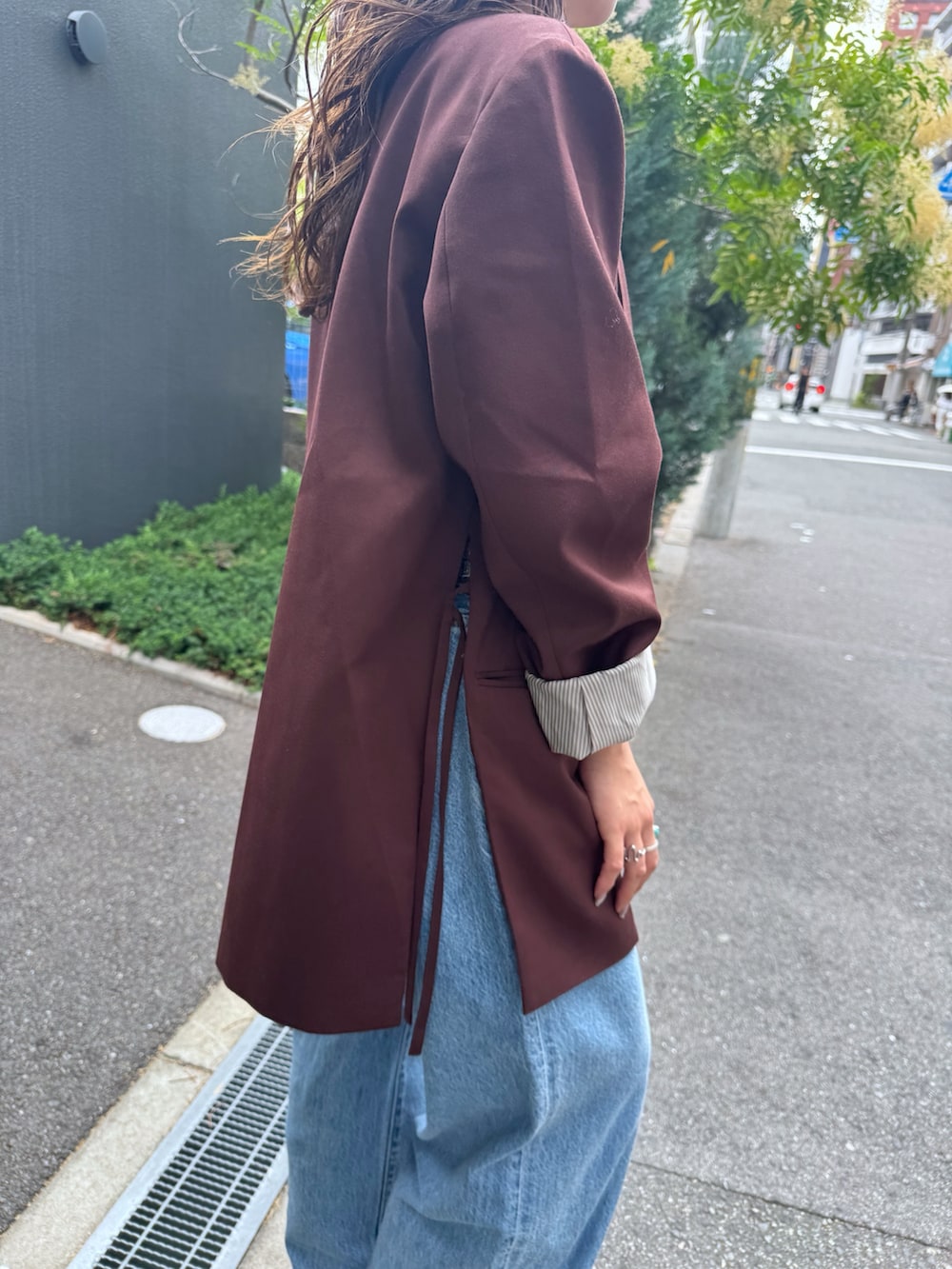 ブルー系のデニムパンツ、ブラウン系のテーラードジャケット、ホワイト系のTシャツ/カットソーを着用したレディースの夏コーディネートの7枚目の写真