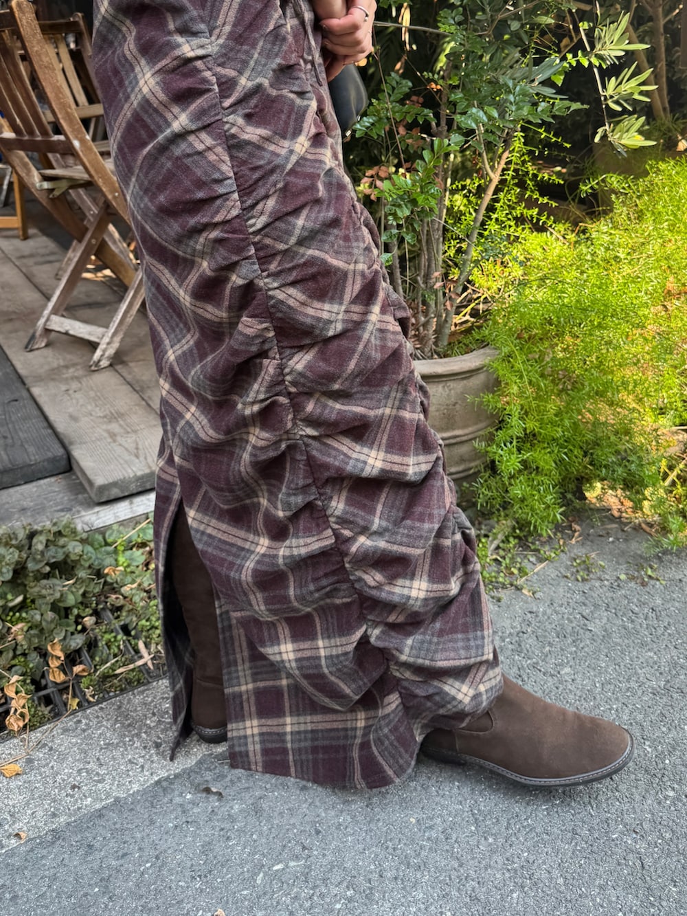 レッド系のワンピース、ブラウン系のブーツを着用したレディースの秋コーディネートの10枚目の写真