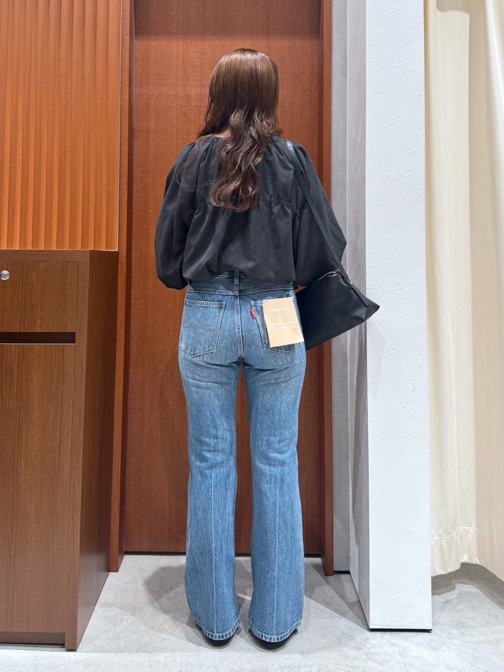 ブルー系のデニムパンツ、ブラウン系のシャツ/ブラウス、ブラック系のハンドバッグを着用したレディースの夏コーディネートの4枚目の写真