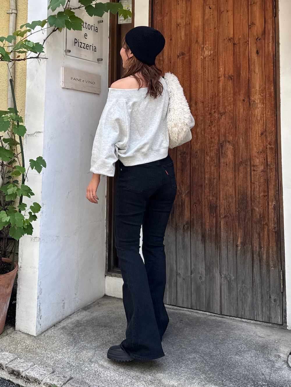 ブラック系のデニムパンツ、グレー系のスウェット、ホワイト系のハンドバッグを着用したレディースの夏コーディネートの4枚目の写真