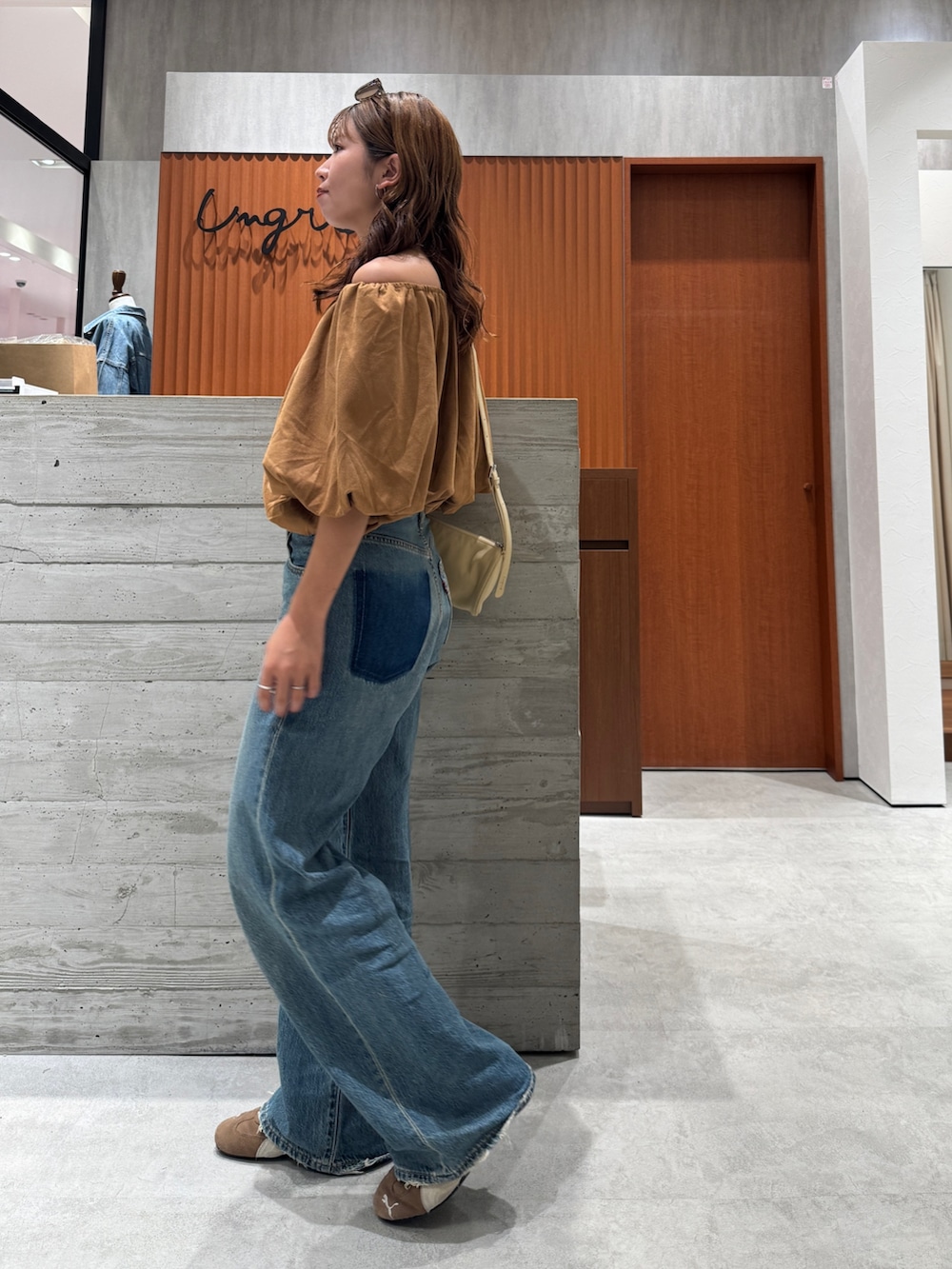 ブルー系のデニムパンツ、イエロー系のシャツ/ブラウス、ブラウン系のサングラスを着用したレディースの夏コーディネートの3枚目の写真