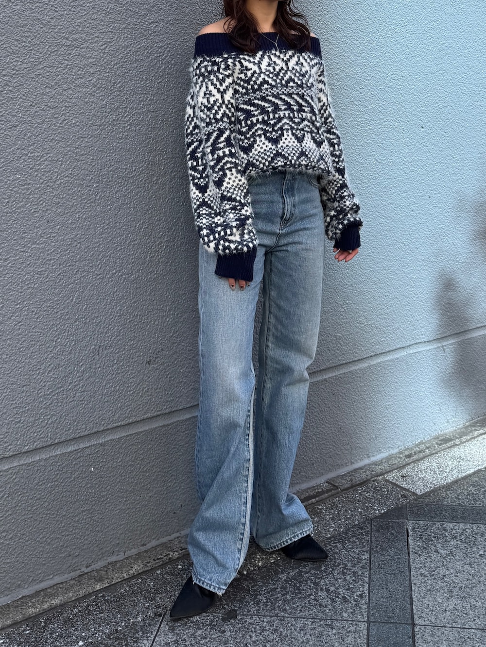 ブルー系のニット/セーター、ブルー系のデニムパンツを着用したレディースの秋コーディネートの7枚目の写真