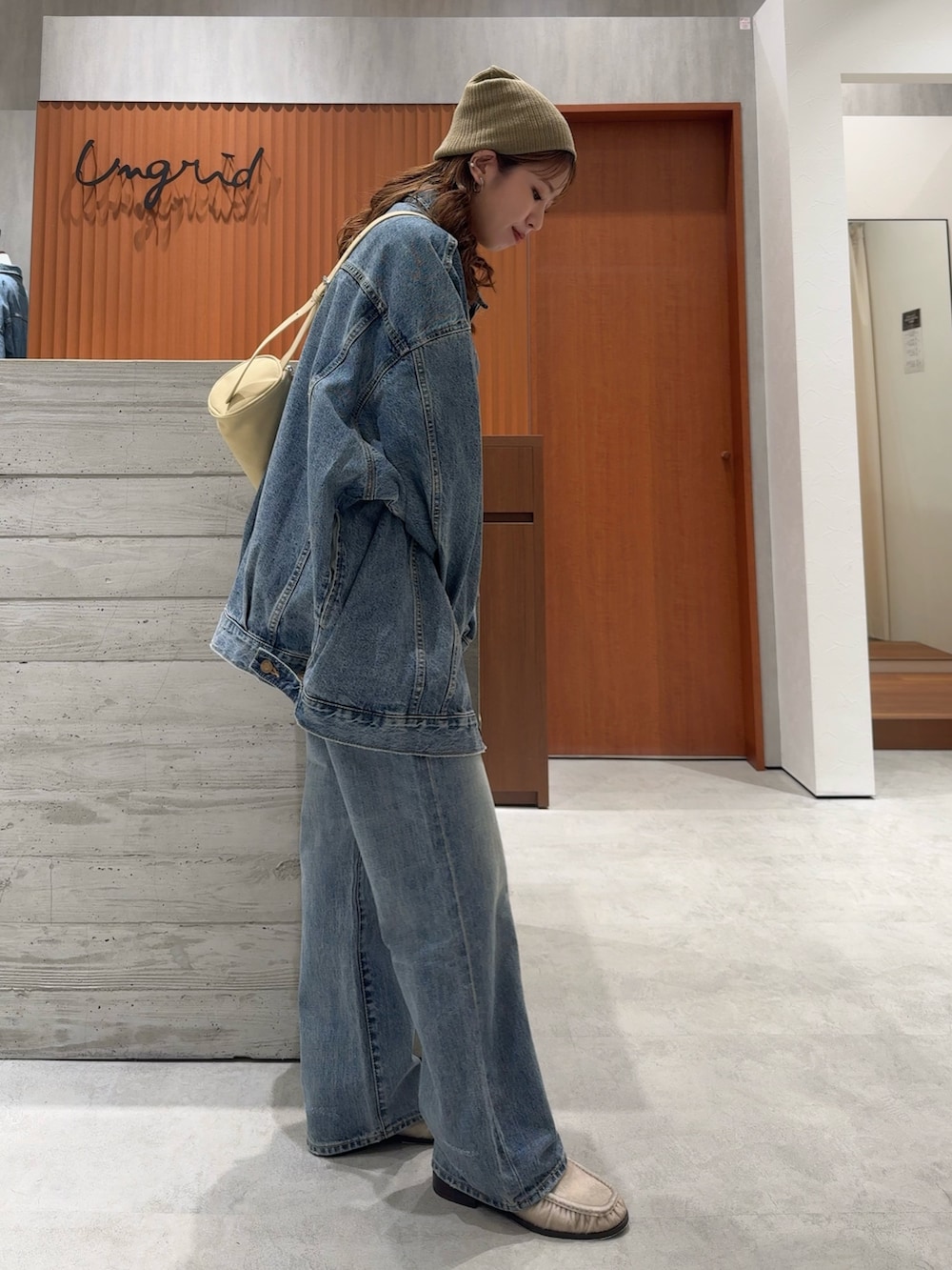 ブルー系のデニムジャケット、ブルー系のデニムパンツ、ホワイト系のタンクトップを着用したレディースの夏コーディネートの3枚目の写真