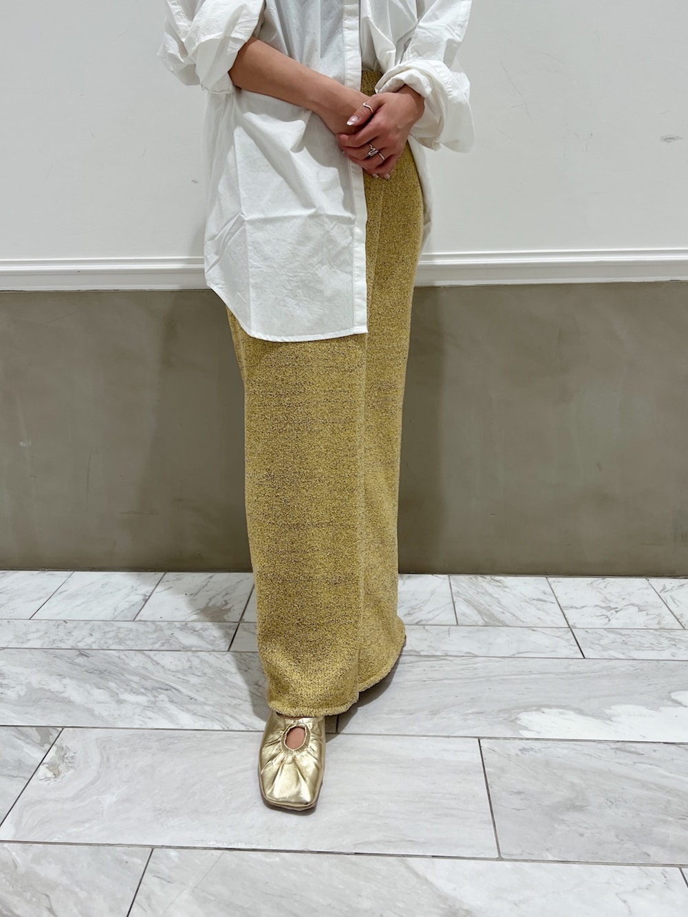 ホワイト系のシャツ/ブラウス、イエロー系のパンプス、ベージュ系のスカートを着用したレディースの冬コーディネートの6枚目の写真