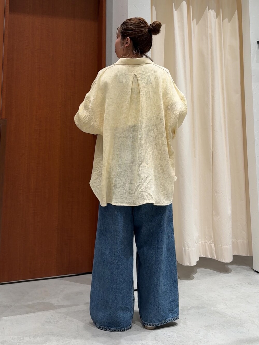 ブルー系のデニムパンツ、ホワイト系のTシャツ/カットソー、イエロー系のシャツ/ブラウスを着用したレディースの春コーディネートの4枚目の写真