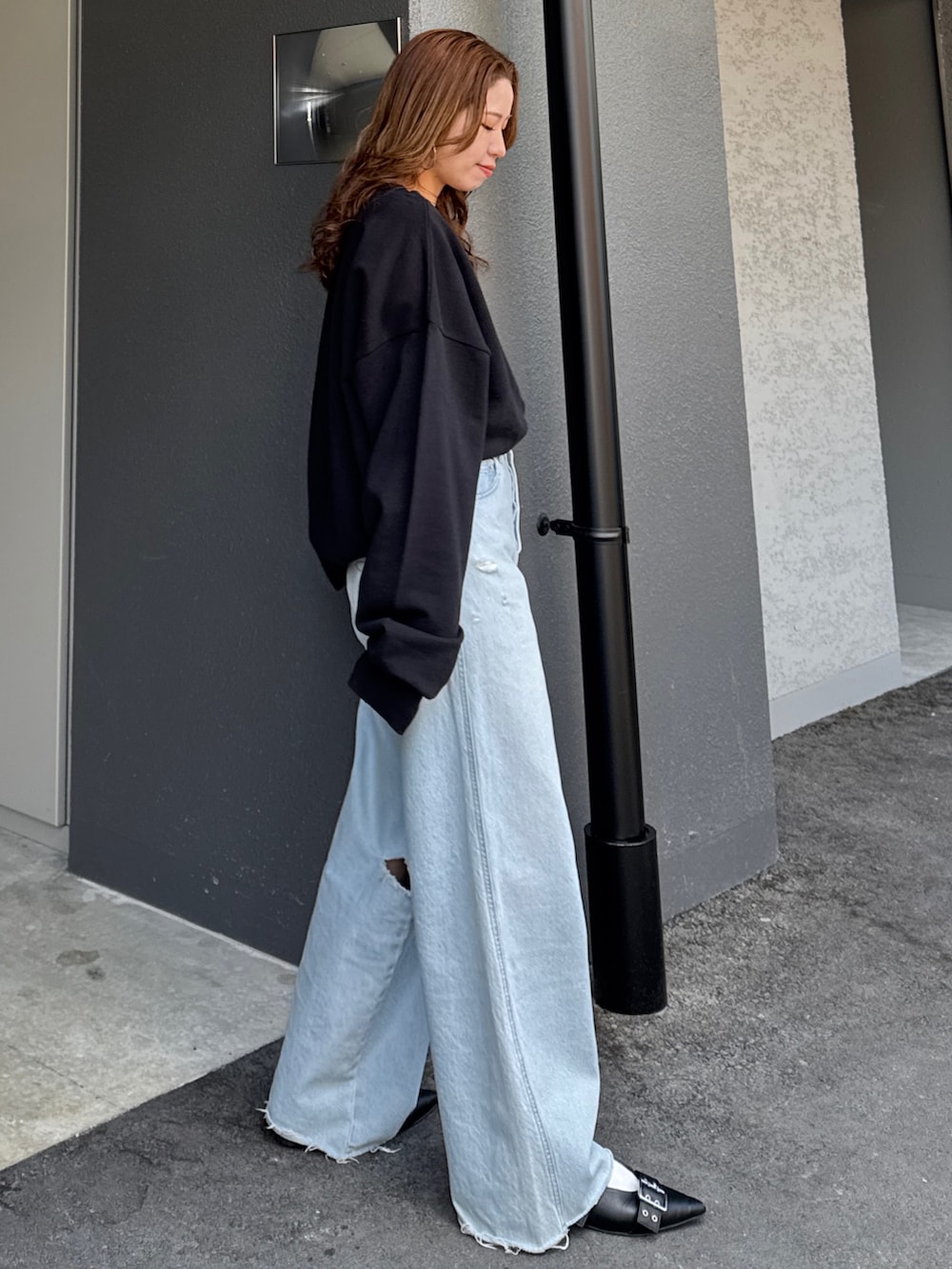 ブラック系のスウェット、グレー系のTシャツ/カットソー、ブルー系のデニムパンツを着用したレディースの春コーディネートの4枚目の写真