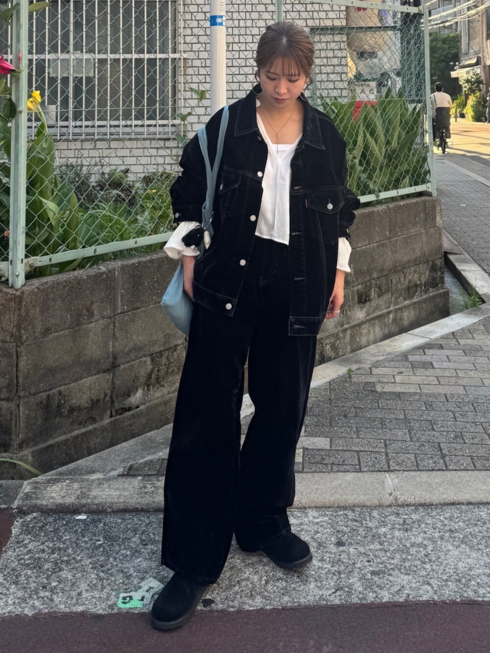 ブラック系のスリッポン、ブラック系のデニムパンツ、ブルー系のトートバッグを着用したレディースの夏コーディネートの2枚目の写真