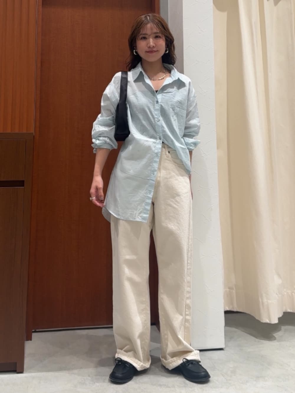 ホワイト系のデニムパンツ、ブルー系のシャツ/ブラウス、ブラック系のローファーを着用したレディースの春コーディネートの2枚目の写真