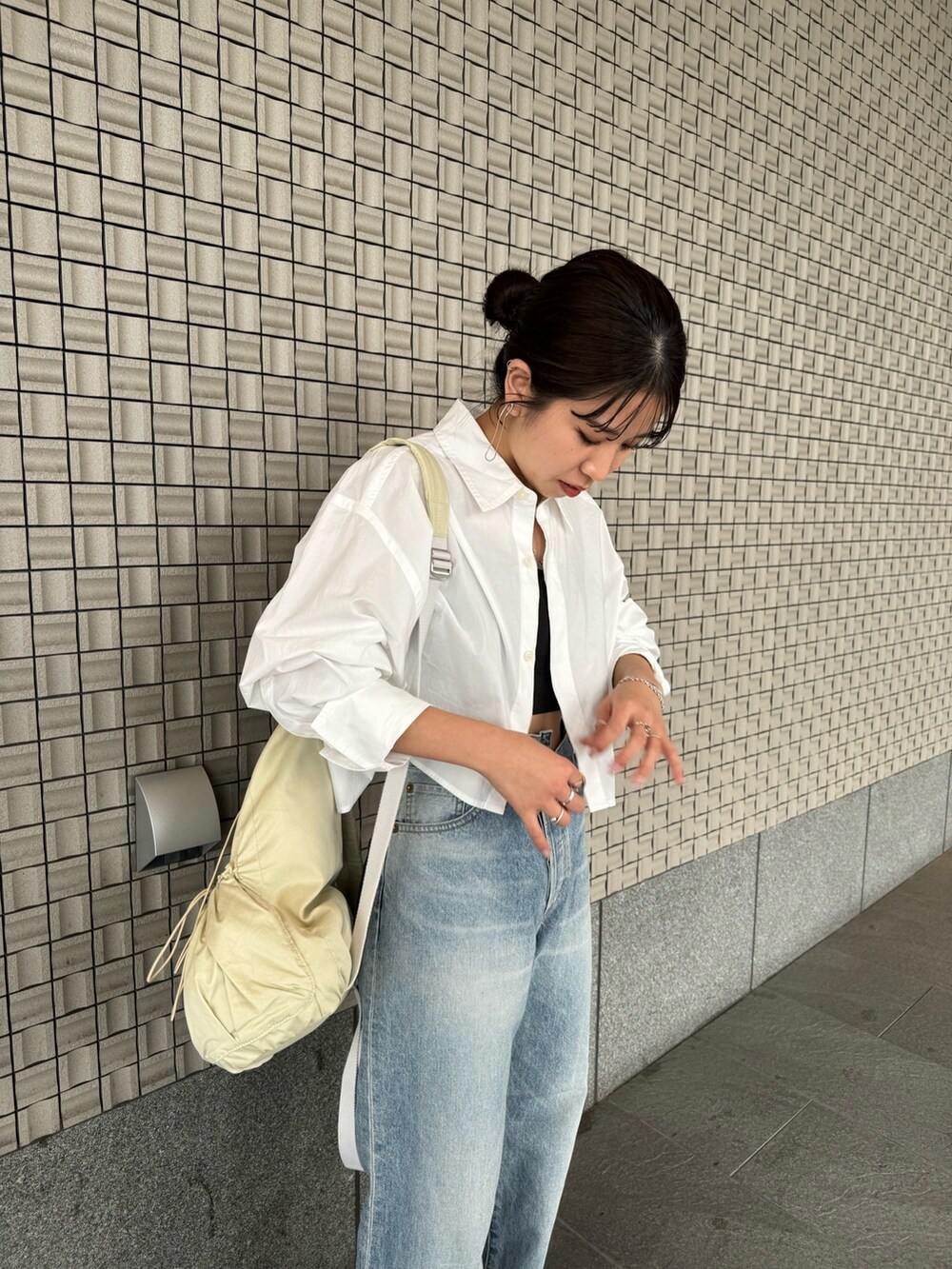 ブルー系のデニムパンツ、ホワイト系のシャツ/ブラウス、ブラック系のキャミソールを着用したレディースの春コーディネートの6枚目の写真